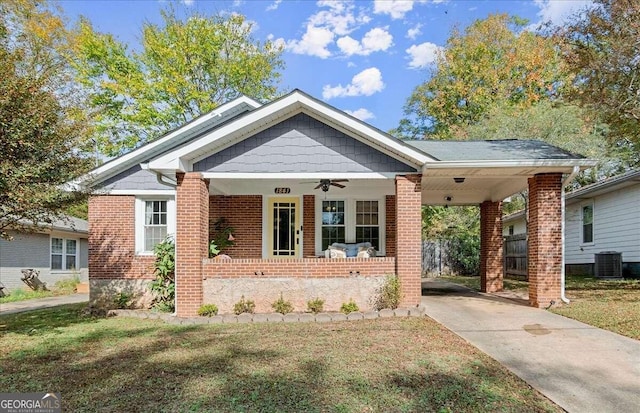 view of front facade featuring central air condition unit, a front lawn, a porch, and a carport