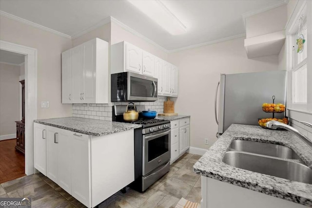 kitchen featuring white cabinets, sink, appliances with stainless steel finishes, tasteful backsplash, and light stone counters