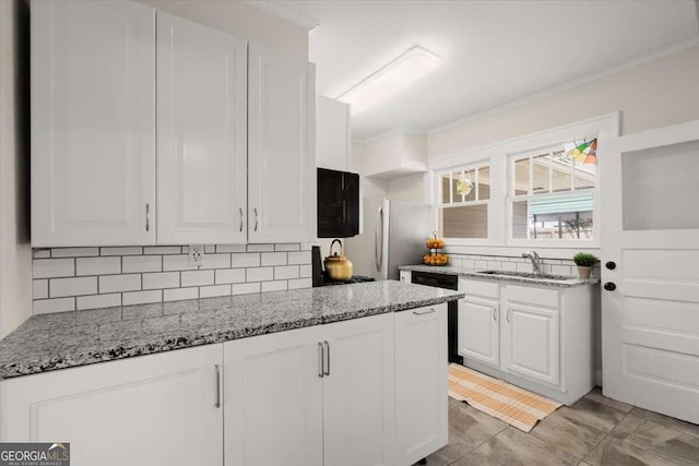 kitchen featuring white cabinetry, sink, light stone counters, white refrigerator, and backsplash