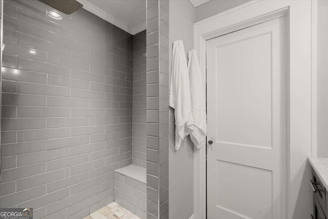 bathroom featuring a tile shower and vanity