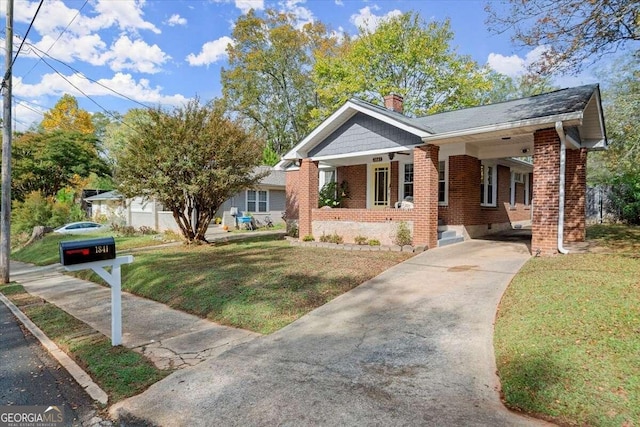 ranch-style house with covered porch, a front yard, and a carport