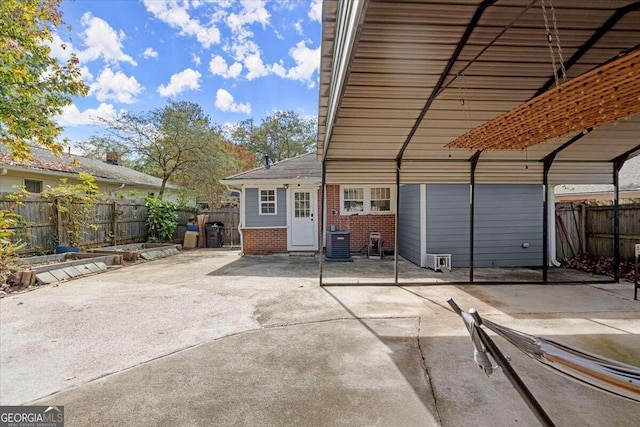 rear view of property with central air condition unit and a patio