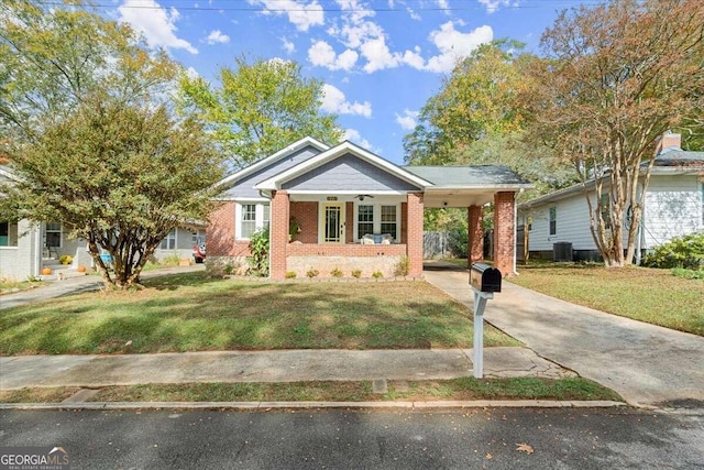 view of front of property featuring a front lawn, central AC, a porch, and a carport