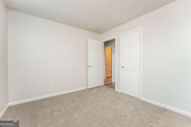 empty room featuring light colored carpet and a textured ceiling