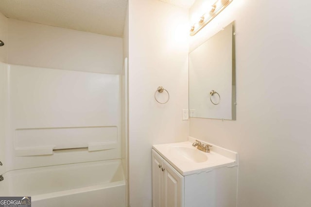 bathroom featuring vanity, a textured ceiling, and tub / shower combination