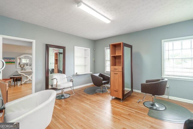 living area with light hardwood / wood-style flooring and a textured ceiling