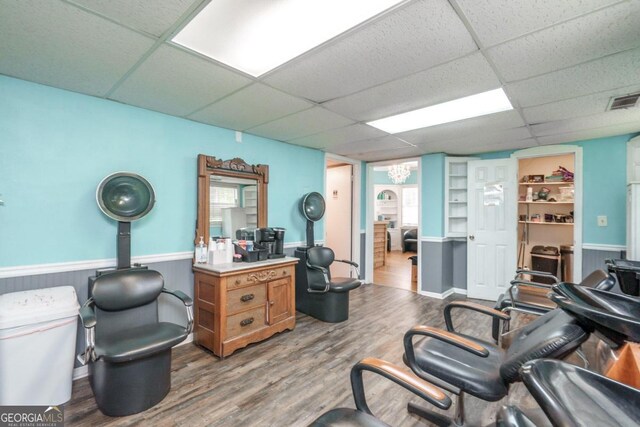 office with wood-type flooring and a paneled ceiling