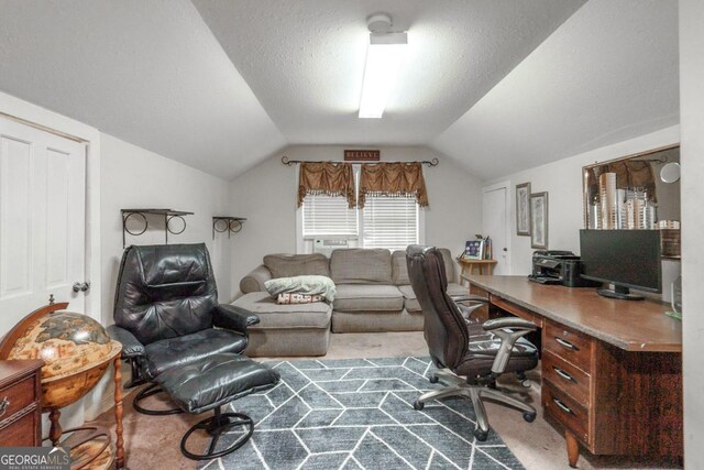 carpeted home office with a textured ceiling and vaulted ceiling