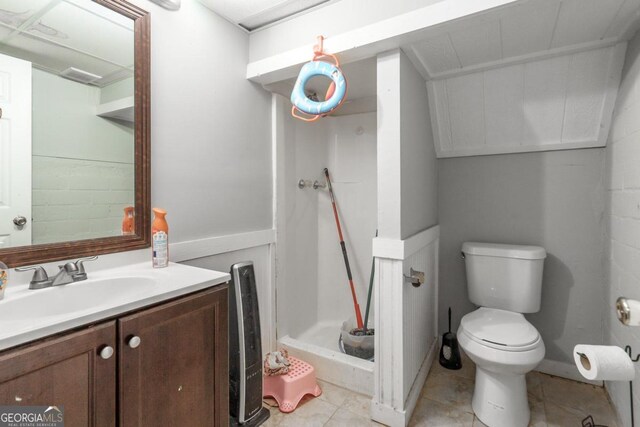 bathroom with toilet, vanity, tile patterned floors, and walk in shower