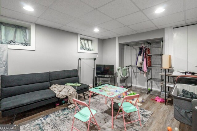 interior space featuring a drop ceiling and hardwood / wood-style flooring