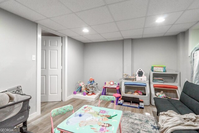 rec room with a drop ceiling and light wood-type flooring