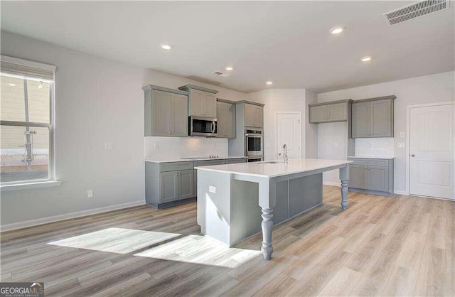 kitchen featuring light hardwood / wood-style flooring, gray cabinetry, and stainless steel appliances