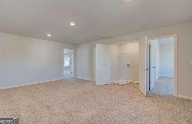 unfurnished bedroom featuring a closet and light colored carpet