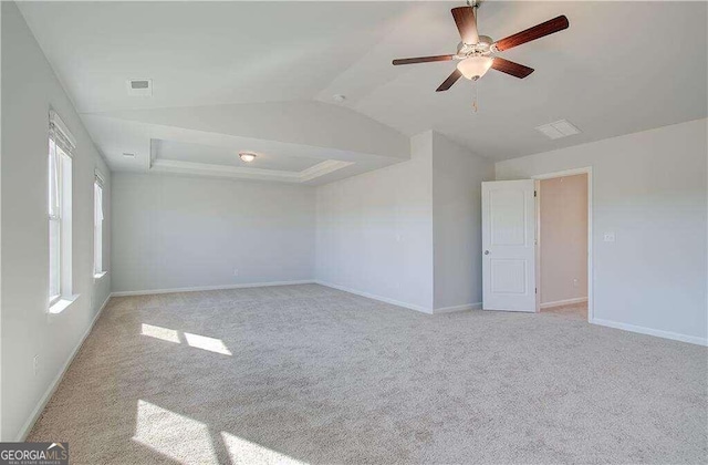 carpeted spare room featuring vaulted ceiling and ceiling fan