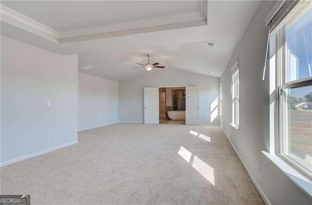 spare room with vaulted ceiling, ceiling fan, light carpet, and plenty of natural light