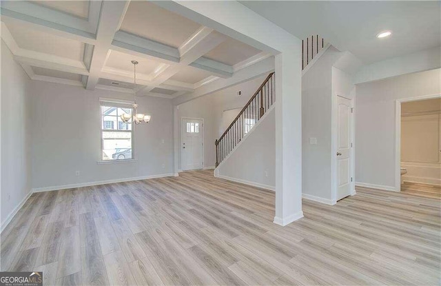 unfurnished living room featuring light hardwood / wood-style flooring, coffered ceiling, beamed ceiling, and a chandelier