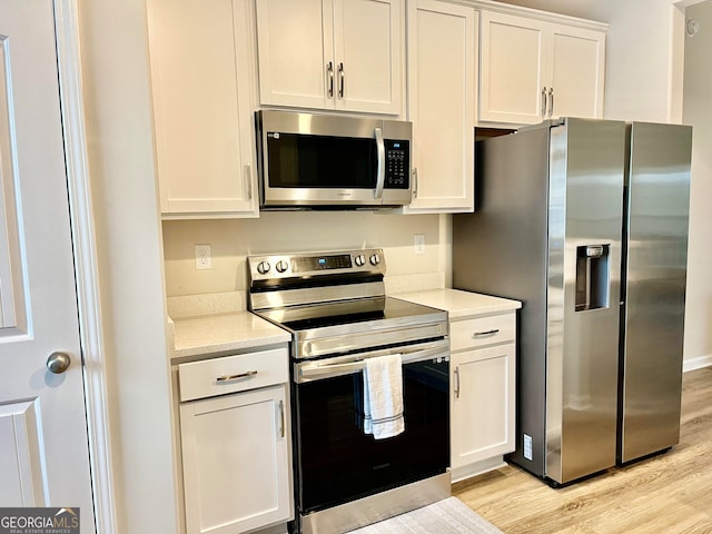 kitchen featuring white cabinets, light hardwood / wood-style floors, and stainless steel appliances