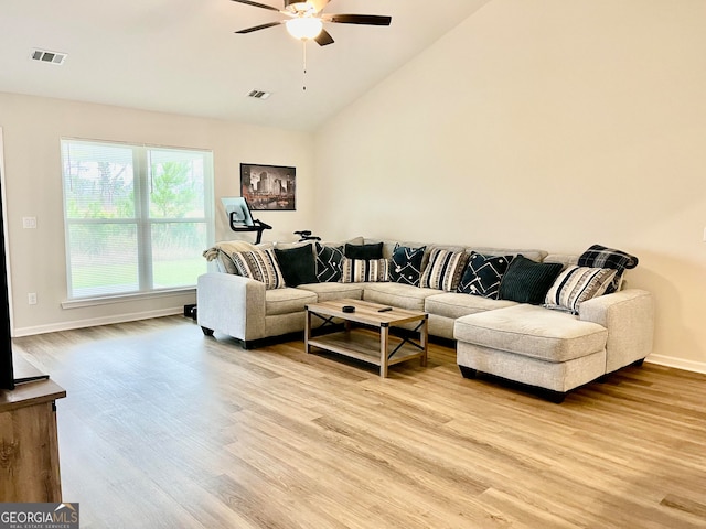 living room featuring ceiling fan, lofted ceiling, and light wood-type flooring