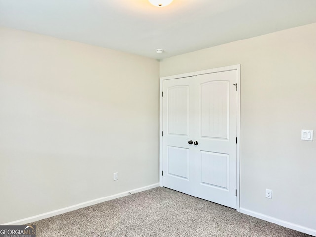 unfurnished bedroom featuring carpet flooring and a closet