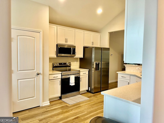 kitchen featuring white cabinets, light wood-type flooring, lofted ceiling, and appliances with stainless steel finishes