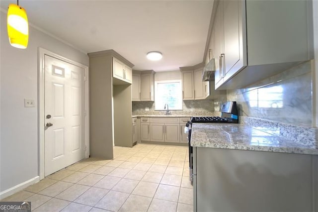 kitchen featuring tasteful backsplash, stainless steel gas range oven, light tile patterned floors, gray cabinets, and hanging light fixtures