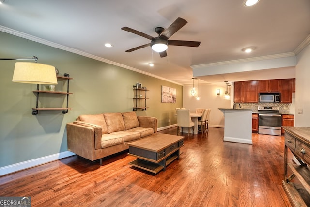 living room with dark hardwood / wood-style flooring, ceiling fan, and ornamental molding