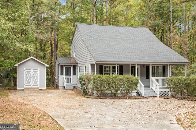 view of front of property featuring covered porch and a shed