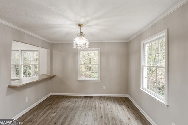 unfurnished room featuring a wealth of natural light, hardwood / wood-style flooring, and crown molding