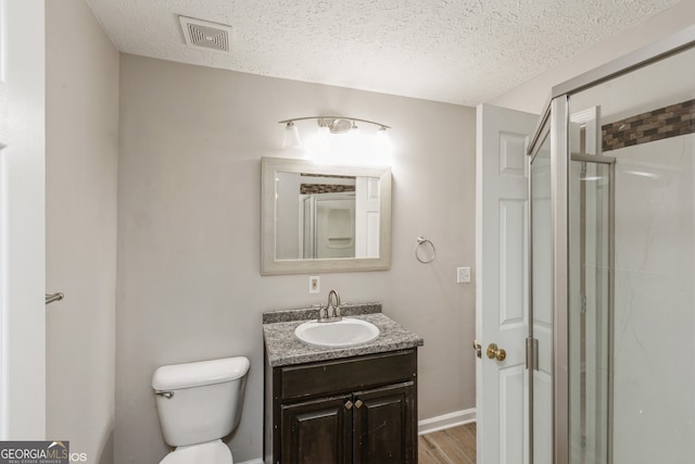 bathroom with hardwood / wood-style floors, vanity, a textured ceiling, and walk in shower