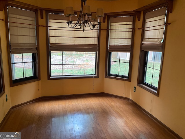 empty room featuring light hardwood / wood-style floors and a notable chandelier