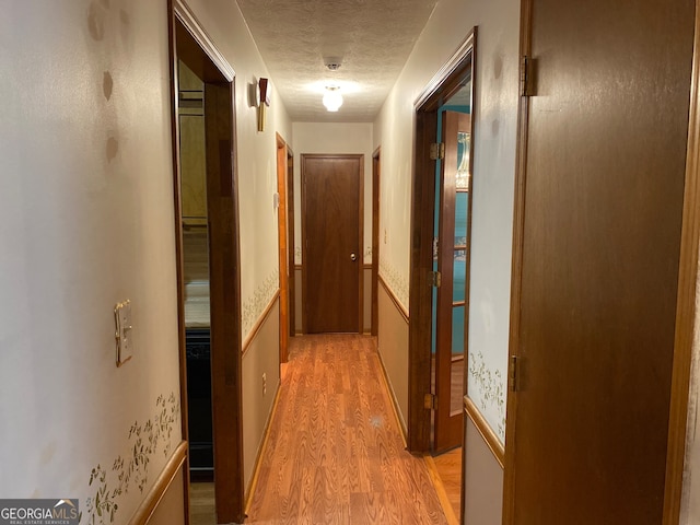 hall featuring hardwood / wood-style floors and a textured ceiling