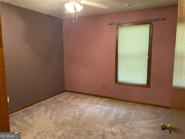 spare room with carpet, ceiling fan, and a textured ceiling