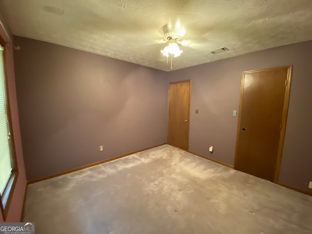 carpeted spare room with a textured ceiling and ceiling fan