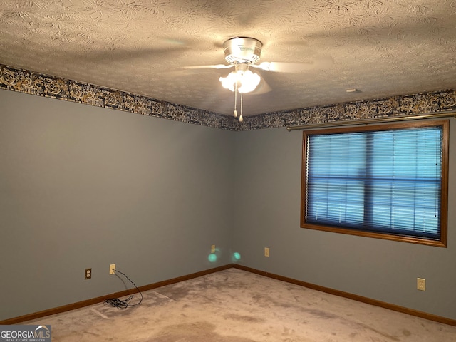 carpeted spare room featuring ceiling fan and a textured ceiling