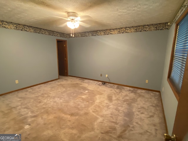 carpeted empty room with a textured ceiling and ceiling fan