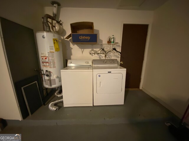 clothes washing area featuring separate washer and dryer and water heater