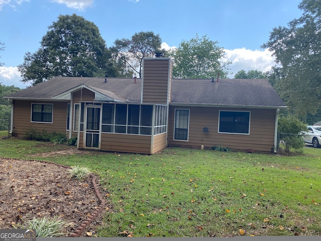 rear view of property with a yard and a sunroom