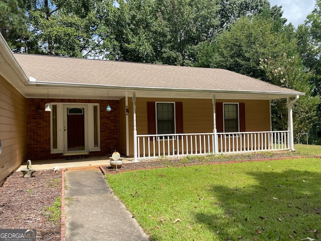 ranch-style house with a front yard and covered porch