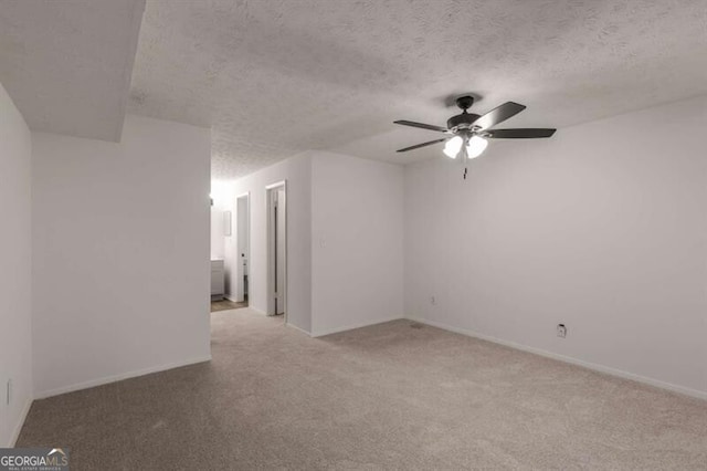 carpeted spare room featuring ceiling fan and a textured ceiling