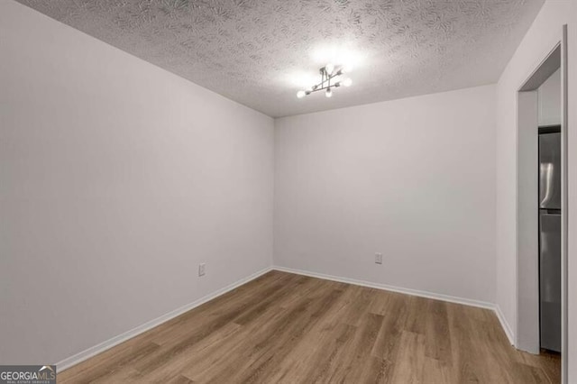 spare room with a textured ceiling and hardwood / wood-style flooring