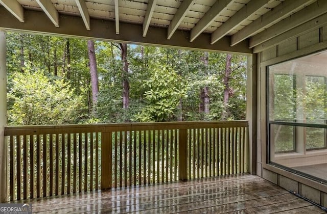 unfurnished sunroom featuring beam ceiling