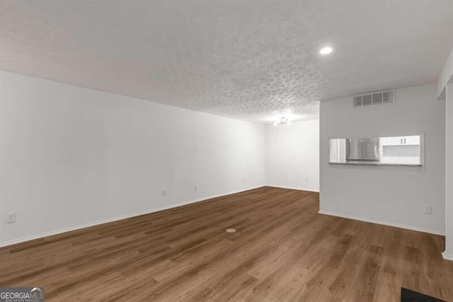 basement featuring hardwood / wood-style flooring and a textured ceiling