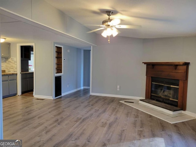 unfurnished living room featuring ceiling fan and light wood-type flooring