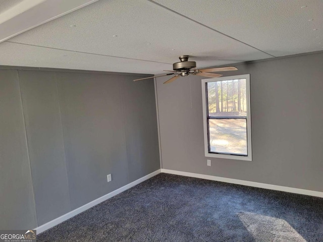 empty room with carpet flooring, ceiling fan, and a textured ceiling