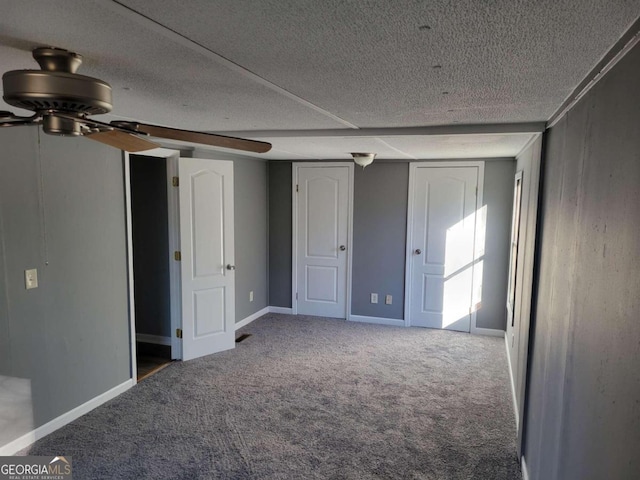 unfurnished bedroom featuring ceiling fan, carpet floors, and a textured ceiling