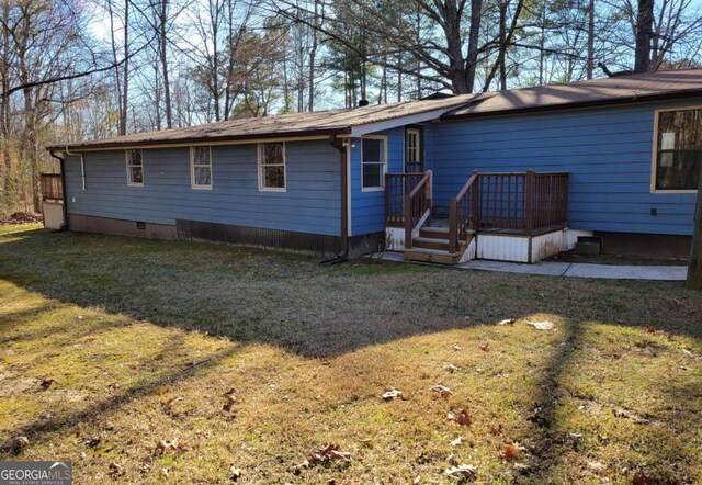 rear view of property featuring a lawn