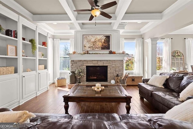 living room featuring dark hardwood / wood-style floors, beam ceiling, coffered ceiling, and a stone fireplace