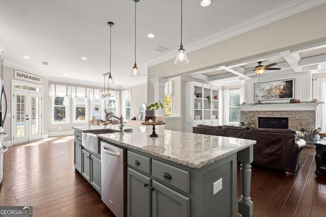 kitchen with stainless steel dishwasher, beamed ceiling, coffered ceiling, a kitchen island with sink, and light stone counters