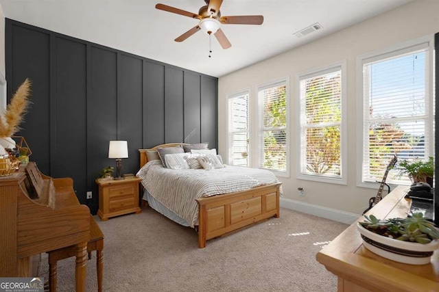 carpeted bedroom with ceiling fan and multiple windows