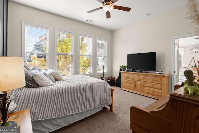 carpeted bedroom with ceiling fan and multiple windows